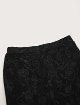 Pantalón de encaje negro con cintura elástica y corte acampanado.