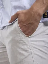 Bermuda color beige claro, de corte casual y largo por encima de la rodilla, con bolsillos laterales.