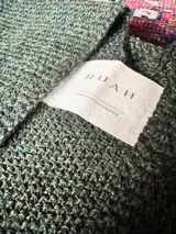 Ruana de tejido de punto color verde inglés, confeccionada en 100% baby alpaca.
