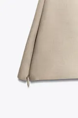 Top color beige de cuello halter con botones y espalda descubierta. Cierre lateral con cremallera oculta.