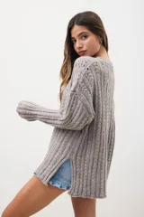 Sweater de punto gris con diseño de trenzas y mangas largas, con un corte relajado.