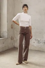 Pantalón de jean marrón de corte wide leg, con cinturón de cuero con hebilla metálica.