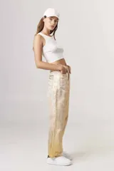 Pantalón de jean metalizado color dorado, de corte recto y tiro alto.