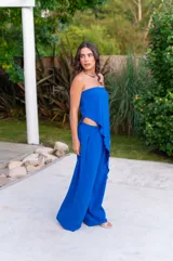 Conjunto de dos piezas color azul eléctrico, compuesto por un top strapless asimétrico con caída y un pantalón ancho de tiro alto.