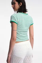 Remera corta de algodón a rayas horizontales blancas y rojas, con cuello y mangas con ribete al tono.