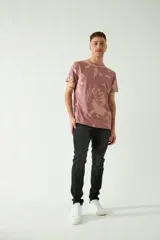 Remera color ladrillo con estampado abstracto en tonos beige y logo de la marca Mistral en el pecho.