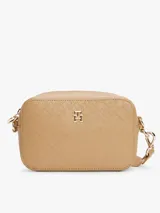 Bandolera Tommy Hilfiger color beige con estampado del logo de la marca en toda la superficie. Tiene correa ajustable con inscripción del monotipo Hilfiger y aplique del monograma TH en la parte delantera.