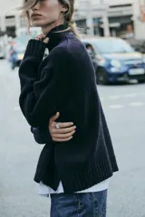 Sweater negro de punto con cuello alto y mangas largas.