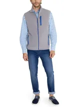 Chaleco polar gris sin mangas, confeccionado en micropolar de poliéster reciclado, con cierre frontal y tres bolsillos con cierre en color azul.