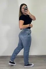 Pantalón jean mom celeste de tiro alto, corte holgado y tobillos ajustados.