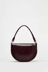 Bolso de hombro ovalado color borgoña, con asa de doble tira redonda con detalles metalizados y cierre imantado. Incluye asa de bandolera extraíble con tejido a contraste y bolso interior con cierre mediante cremallera metálica.