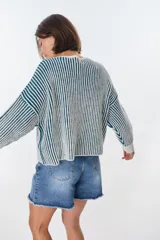 Sweater de punto grueso a rayas verticales en color azul petróleo y borgoña, de corte holgado y mangas largas.