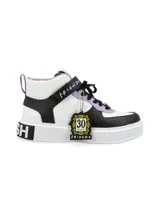 Zapatillas de media caña blancas con detalles en negro y lila. Cierre con cordones negros y tira de velcro blanca con la palabra "Friends".