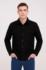 Sobrecamisa negra de poliéster con solapa, manga larga y dos bolsillos frontales con botón.