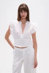 Top blanco de manga corta con escote en V, detalles bordados de hojas y puntos, pinzas, punto smock en la cintura y volados en los hombros.