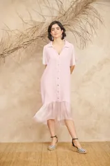 Vestido camisero midi color rosa claro, de lino, con cuello camisero, manga corta y falda con volados.
