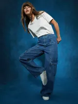 Pantalón de jean de tiro alto, color azul medio, con corte ancho y pierna recta. Presenta costuras marcadas en el centro de las piernas y bolsillos cargo a los lados.