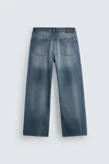 Pantalón de jean negro con corte flare y estilo baggy, con cinco bolsillos, efecto lavado y cierre frontal con botones.