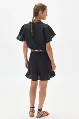 Camisa negra de lino con cuello mao, mangas cortas acampanadas y botonadura frontal con botones de nácar.