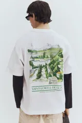 Remera blanca de algodón pesado con cuello redondo y estampado pequeño en el pecho. Corte oversized con hombros caídos y bajo recto.