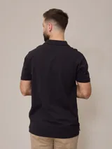 Chomba azul marino de piqué de algodón con cuello clásico y tapeta de dos botones. Logo bordado en el pecho. Corte clásico.