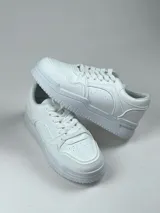Championes de simil cuero en color blanco y negro, con suela confortable y diseño deportivo.