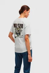 Remera color beige de corte holgado y mangas cortas.