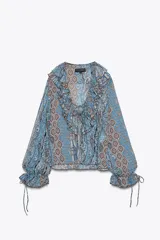 Camisa de manga larga con estampado cachemir en tonos celeste, azul y marrón. Presenta escote en V con volantes y lazos.