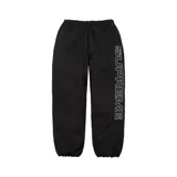 Pantalón negro de nylon con el logo de Supreme bordado en blanco en la pierna derecha y bolsillo frontal.