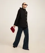 Saco gris de polivelour con capucha, cuello alto con cremallera, abotonado delantero cruzado, bolsillos delanteros y mangas largas.