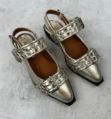 Ballerinas negras de cuero con punta cuadrada, tira sobre el empeine con hebilla metálica y detalle de ojalillos plateados.
