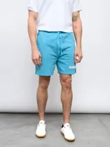 Bermuda deportiva azul marino de piqué con cintura elástica ajustable con cordón, bolsillos laterales y logo Umbro bordado en blanco.