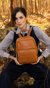 Mochila color marrón con bolsillo frontal grande, asa de mano y correas regulables.