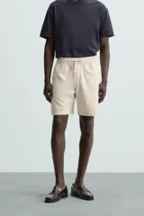 Bermuda de algodón color marrón oscuro, de corte regular fit, con cintura elástica ajustable mediante cordón. Presenta bolsillos laterales y un bolsillo trasero de vivo.