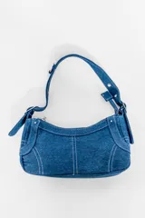 Cartera baguette de denim azul con costuras blancas.