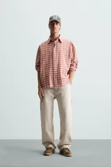 Pantalón gris de corte relaxed fit, con cinco bolsillos, efecto lavado, aplicación de tira y bolsillo multifunción en perneras. Cierre frontal con cremallera y botón.