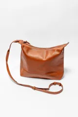 Bolso tipo hobo de cuero sintético color rojo oscuro con textura granulada.