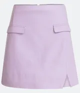 Minifalda evasé color lila de cuero sintético con bolsillos de parche y abertura lateral. Cierre trasero con cremallera.