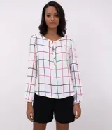 Blusa de crepe blanca con estampado a cuadrillé en tonos azul, rojo, verde y negro. Tiene mangas largas con puños elásticos y ajuste con lazos en el escote.