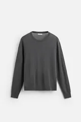 Jersey gris oscuro de lana con acabado mercerizado, corte relaxed fit, cuello redondo y mangas largas con terminaciones en rib.