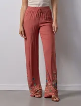 Pantalón verde oliva de rayón con cintura elastizada tipo smock y bordados florales en los bajos.