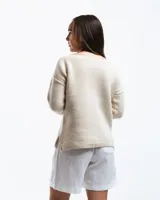 Sweater color crema de lana merino con cuello bote y mangas largas.