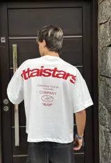 Remera color crema de corte holgado con estampado en rojo en la espalda con el texto "Ittaistars European Tour by Ittai Stars Company".