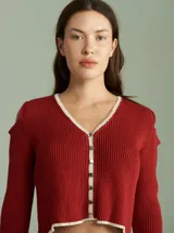 Saco de algodón verde con aberturas en hombros y codos, de corte entallado. Tiene cuello en V, botones pequeños y plaqueta de tejido puño color crudo.