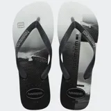 Ojotas Havaianas con base blanca con estampado de paisaje marítimo en blanco y negro, y tiras negras con textura.