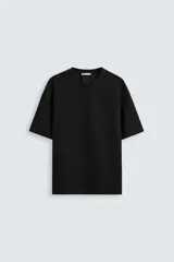 Camiseta negra de corte holgado, con cuello redondo y mangas cortas.