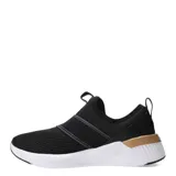 Championes Puma Softride Harli Slip On, color negro con detalles dorados y suela blanca. Diseño slip-on con bandas elásticas cruzadas en el empeine y logo de Puma en dorado.