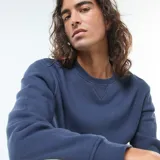 Buzo liso de cuello redondo color azul marino, confeccionado en felpa perchada.