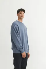 Buzo básico negro de felpa con friza, de calce oversize.
