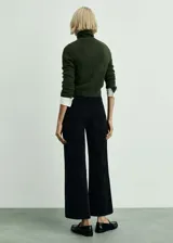 Pantalón culotte de pana color negro, tiro alto, con cierre de cremallera y botón, trabillas, dos bolsillos de parche delanteros y dos bolsillos de parche traseros.